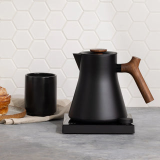 FELLOW Corvo EKG Pro Studio Edition electric kettle with sleek design and digital controls on a kitchen countertop.