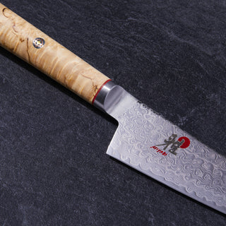 Miyabi Birchwood SG2 5-inch prep knife with wooden handle and sharp blade for precise kitchen slicing.