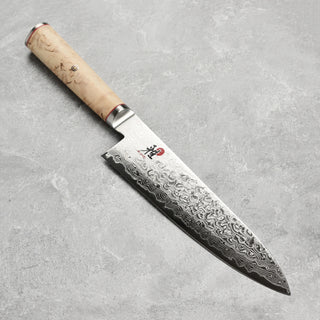 Miyabi Birchwood SG2 9-inch chef knife with a sharp blade and elegant wooden handle, ideal for precise kitchen cutting tasks.