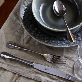 Costa Nova Nau Polished flatware set of 5, including forks, knives, and spoons, with a sleek, polished stainless steel finish.