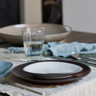 Stacked organic oval dinner plates from Costa Nova 2201 DINNERWARE line, showcasing their textured ceramic finish and elegant design.