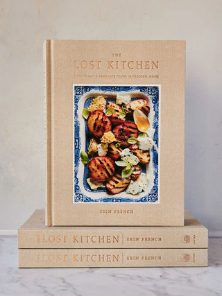 Open cookbook from The Lost Kitchen 2102 Cookbooks by Penguin Random House LLC, featuring pages with recipes and culinary imagery.