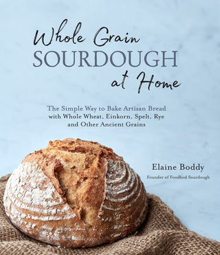 Book cover of 'Whole Grain Sourdough at Home' with a loaf of bread on a textured surface.