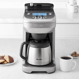 Breville The Grind Control 1502 coffee maker with digital display, carafe, and control panel for brewing fresh coffee.