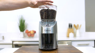 Capresso Infinity Plus conical burr grinder with sleek design, showing the grinder's bean hopper and grinding mechanism.